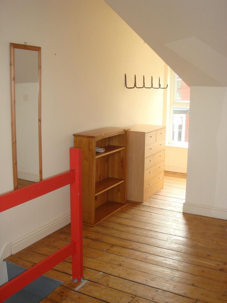 Bright top-floor landing with polished wooden f...