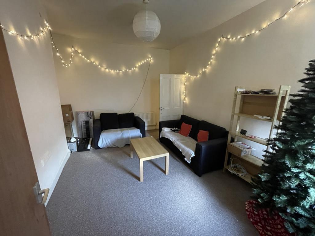 A cozy living room adorned with fairy lights, p...