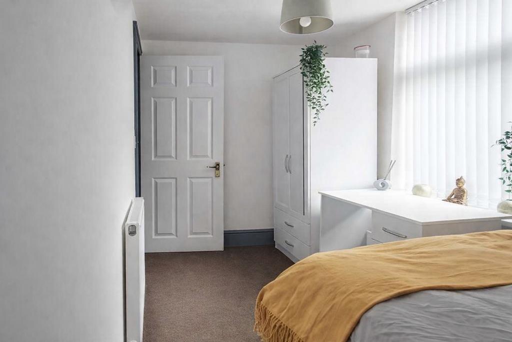 Bright, softly furnished bedroom with a large w...
