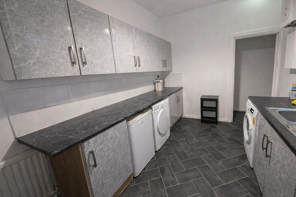 Bright, modern galley kitchen with matching gre...