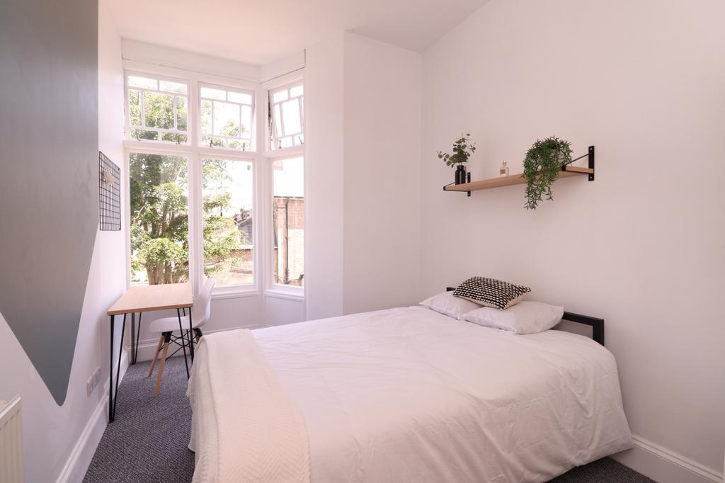 A bright and inviting double bedroom with large...