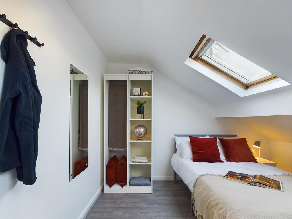 This inviting double bedroom features a cozy at...