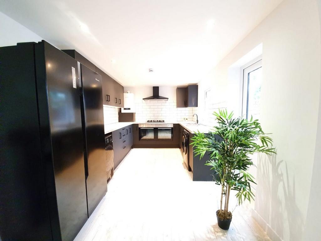 A spacious and modern kitchen featuring sleek b...