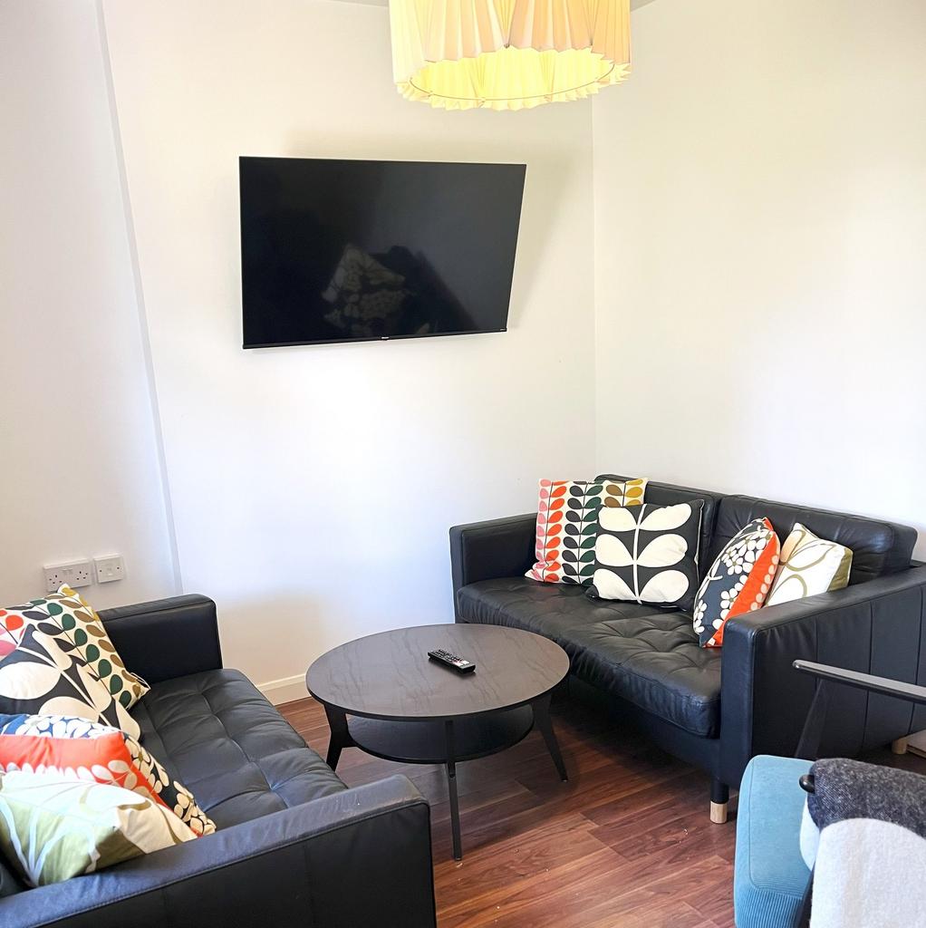 Bright, modern lounge with two black leather so...