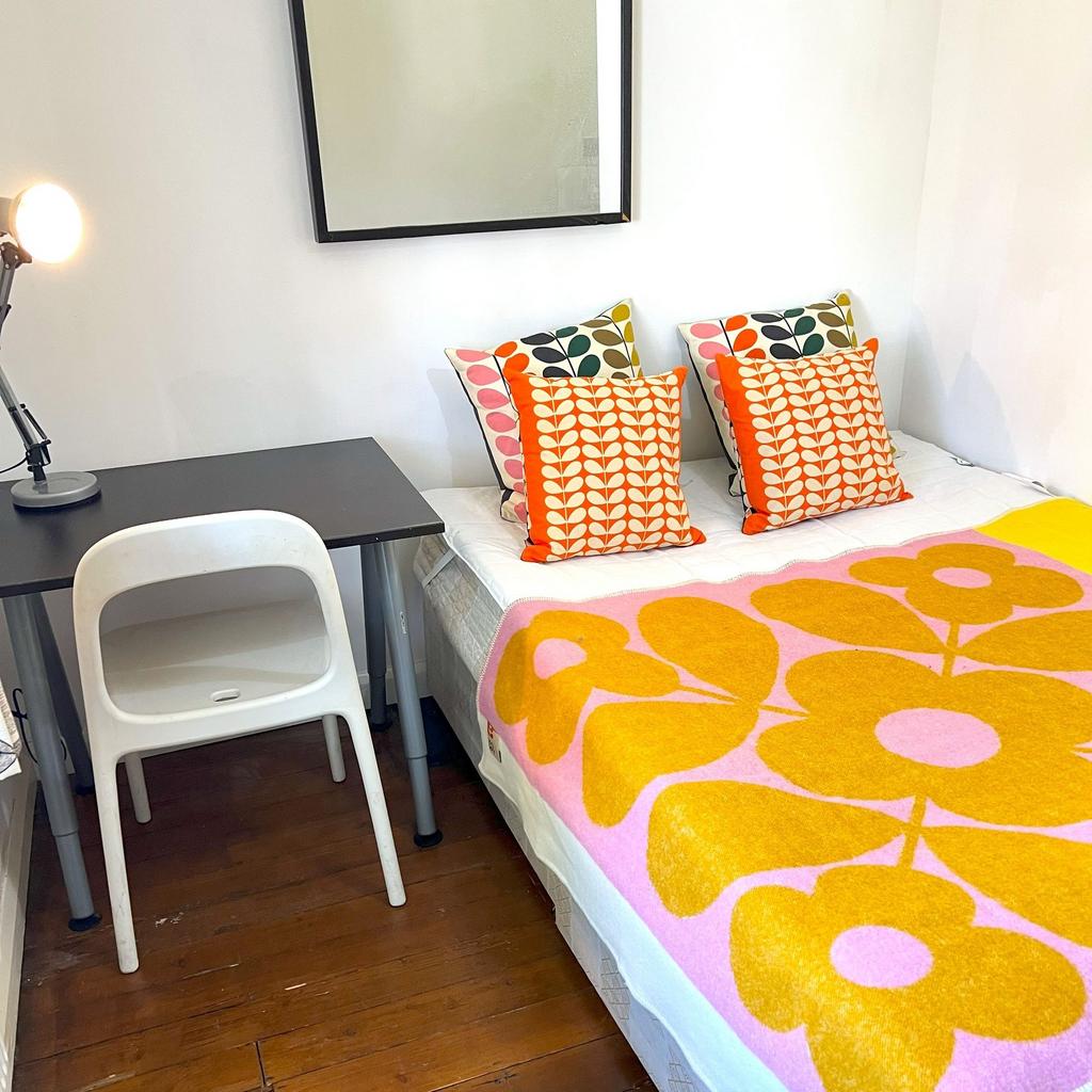Bright, cozy bedroom with colorful patterned cu...
