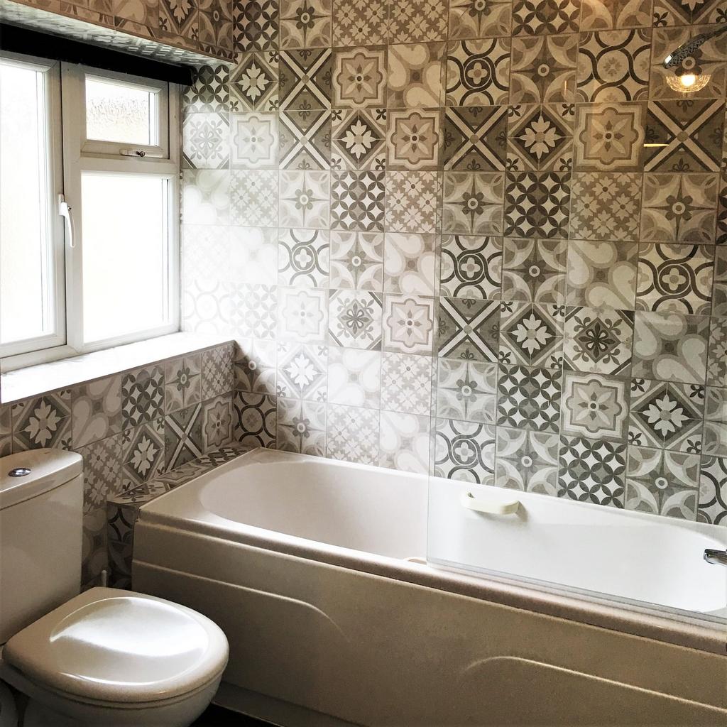 Bright, modern bathroom with patterned feature ...
