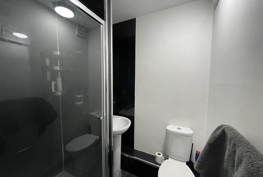 Compact modern bathroom with a corner shower en...