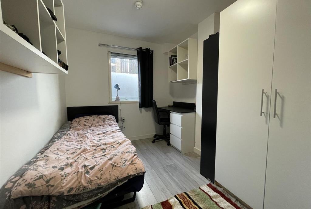 Neat single bedroom with fitted storage, a stud...