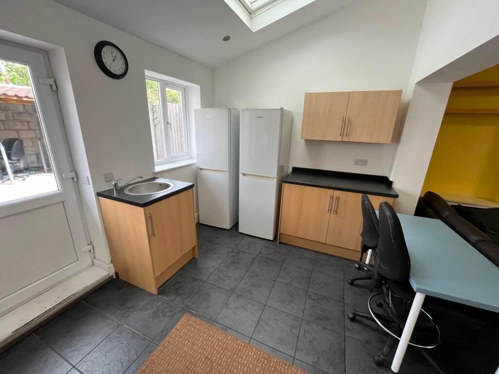 Bright, modern kitchen with tiled flooring, two...