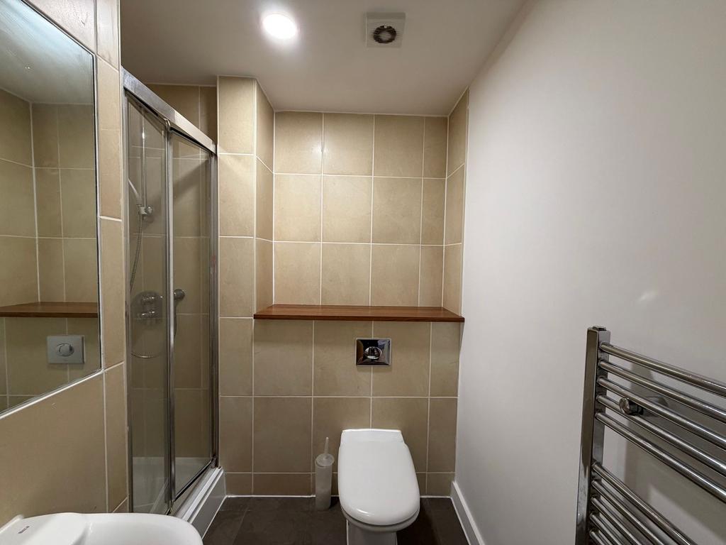 Modern tiled bathroom with a walk-in shower, wa...