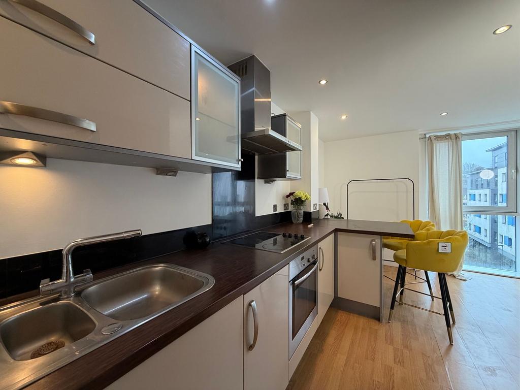 Contemporary open-plan kitchen with dark wood c...