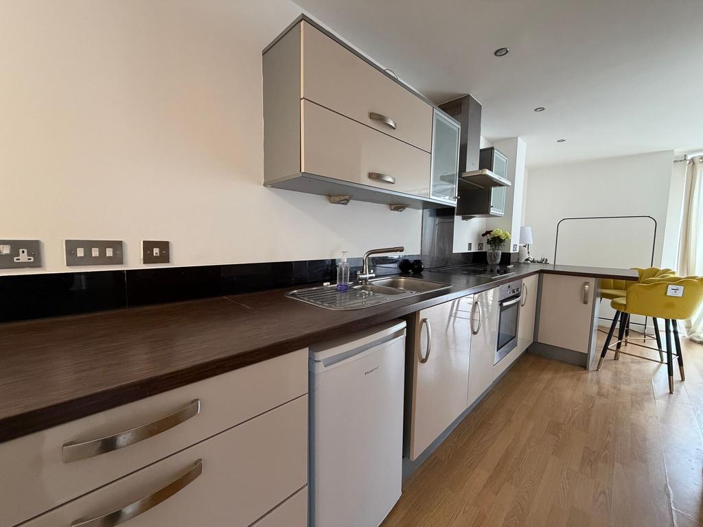 Modern galley kitchen with dark wood countertop...