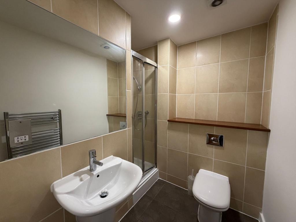 Modern tiled bathroom with a pedestal sink, gla...