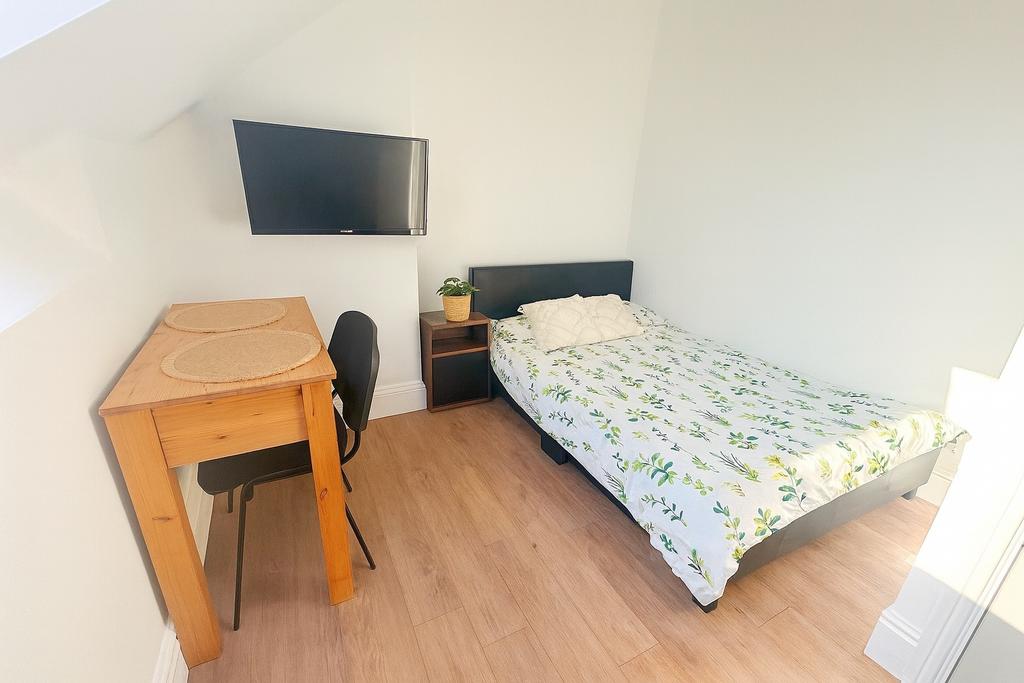 Bright, simply furnished single bedroom with a ...