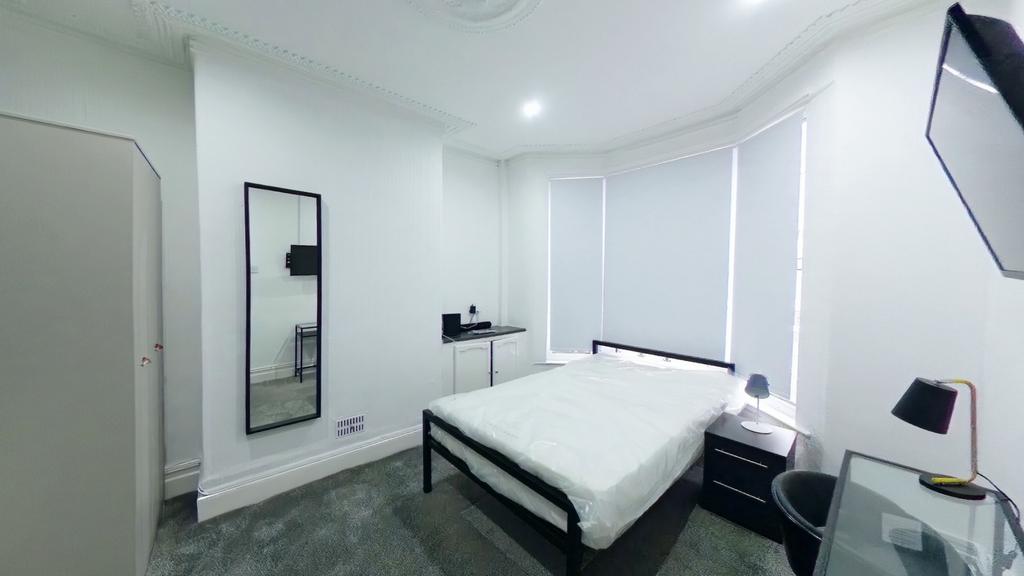 A bright and spacious double bedroom with moder...