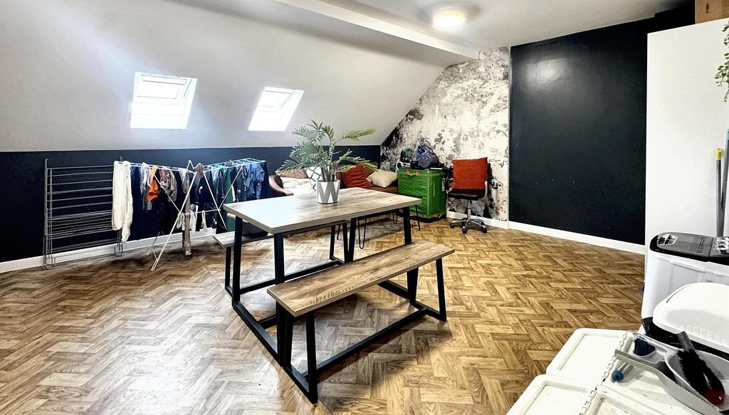 Bright, modern communal lounge with angled skyl...