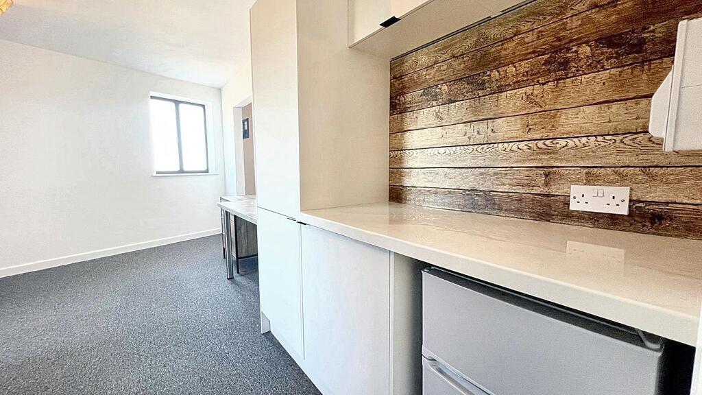 Bright, modern kitchenette with a long work sur...