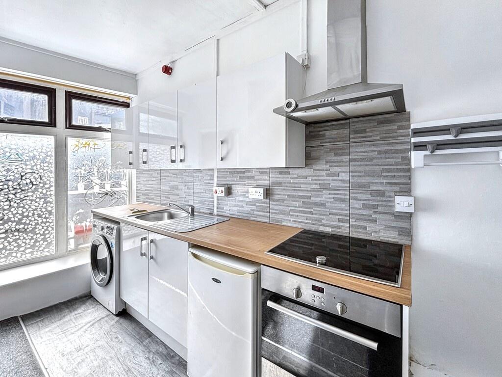 Bright modern galley kitchen with white cabinet...