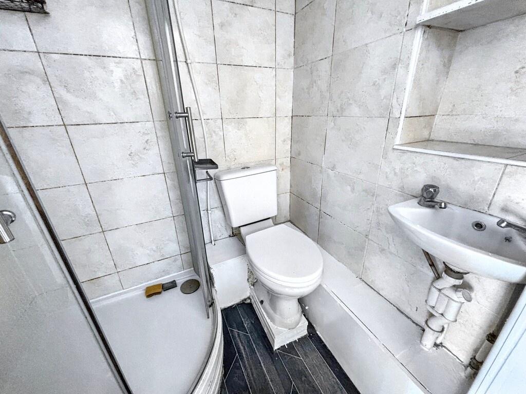 Compact, modern bathroom with a curved-glass sh...