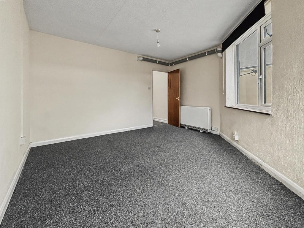 Bright, neutral double bedroom with a large win...