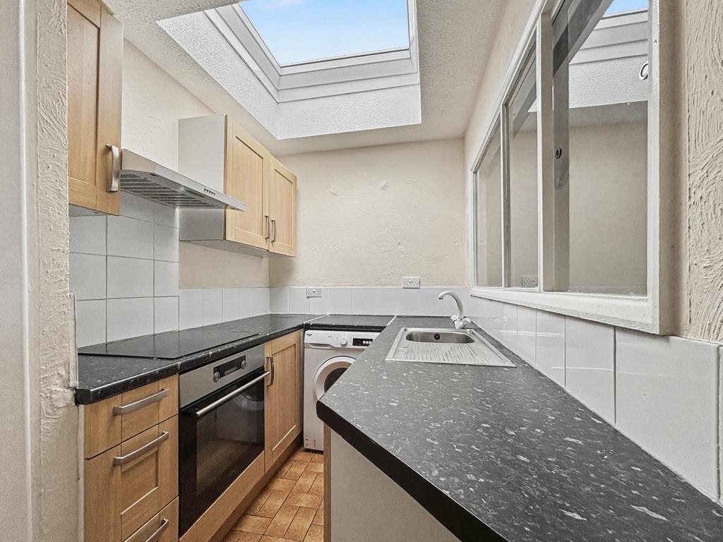 Bright galley kitchen with modern appliances, s...