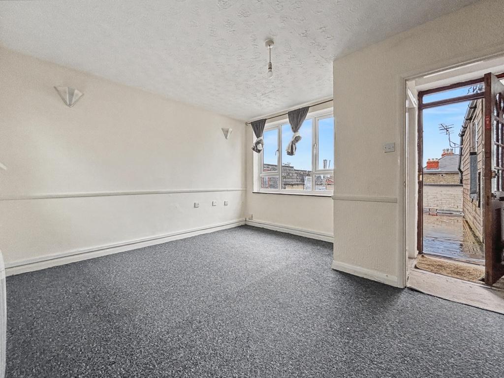 Bright, neutral living room with large front wi...