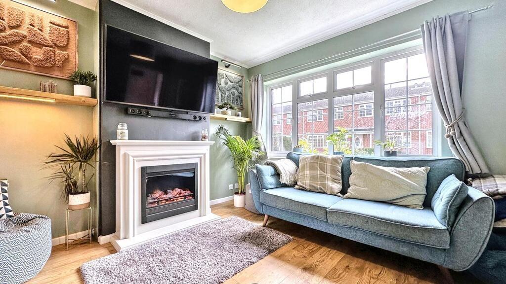 Bright, stylish living room with a large bay wi...