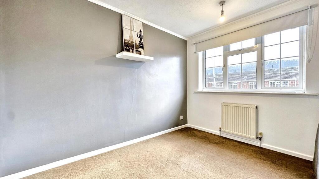Bright, neutral bedroom with a large window let...