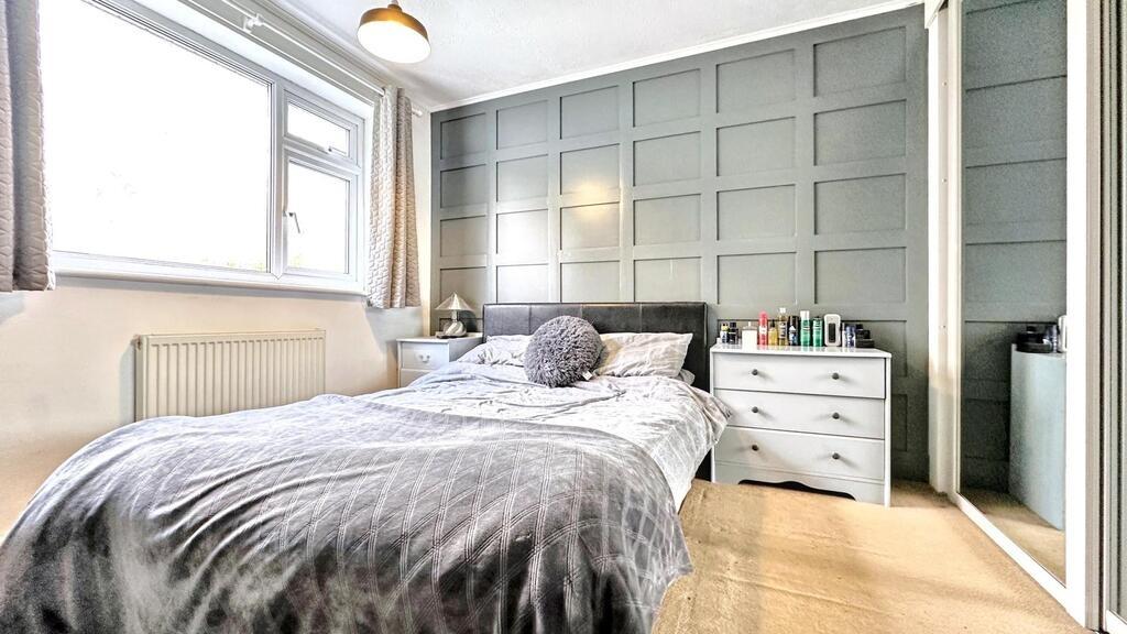 Bright, modern bedroom with a stylish paneled f...