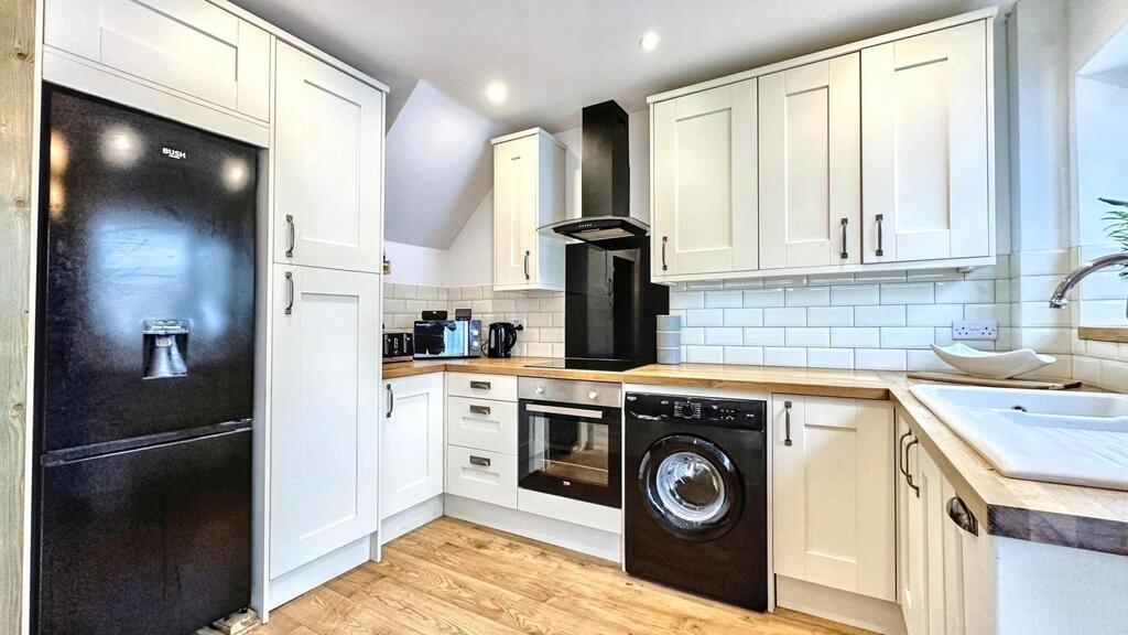 Bright, modern kitchen with white shaker-style ...