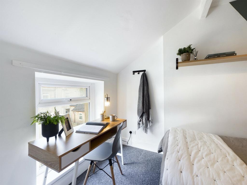A bright and tidy double bedroom featuring a st...