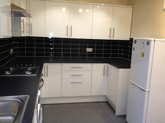Modern fitted kitchen with glossy white cabinet...