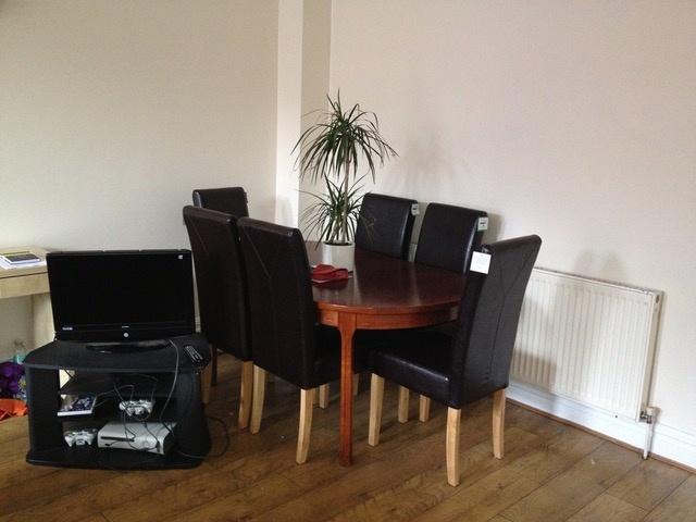 Bright dining area with a round wooden table an...
