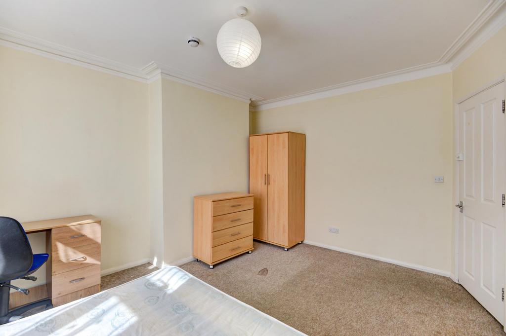 A bright and simple bedroom featuring a wardrob...