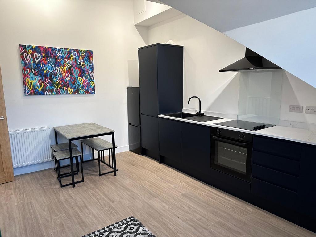 Modern open-plan kitchen with sleek black cabin...
