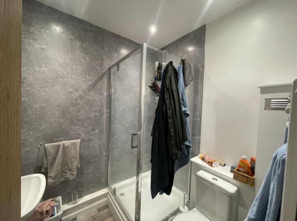Modern bathroom with a corner glass shower encl...