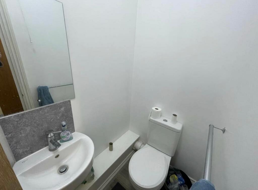 Compact WC with a modern white toilet and small...