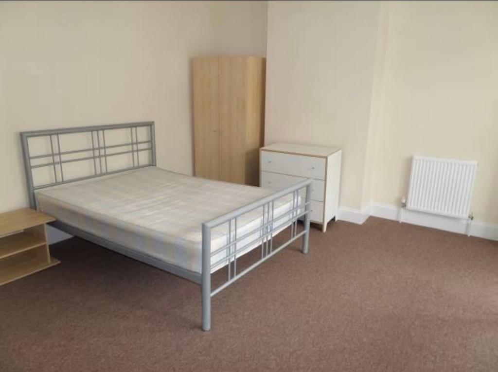 Bright furnished bedroom with a metal double be...