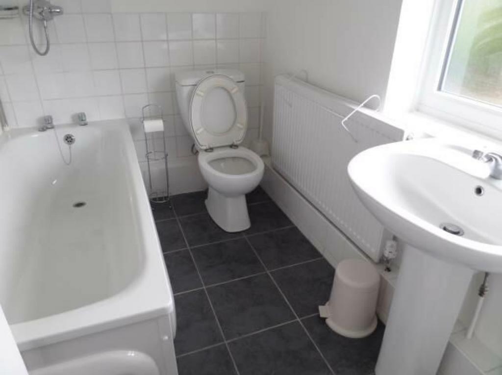 Bright white bathroom with a full-size bath, pe...