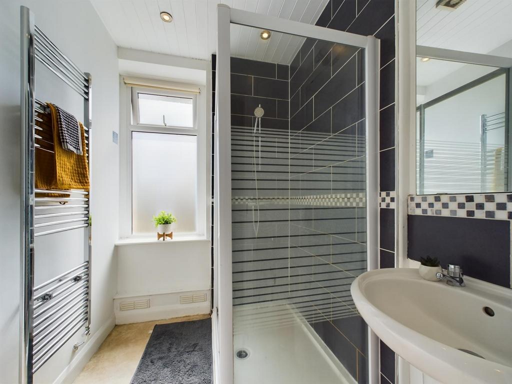 A modern, clean bathroom featuring a glass-encl...