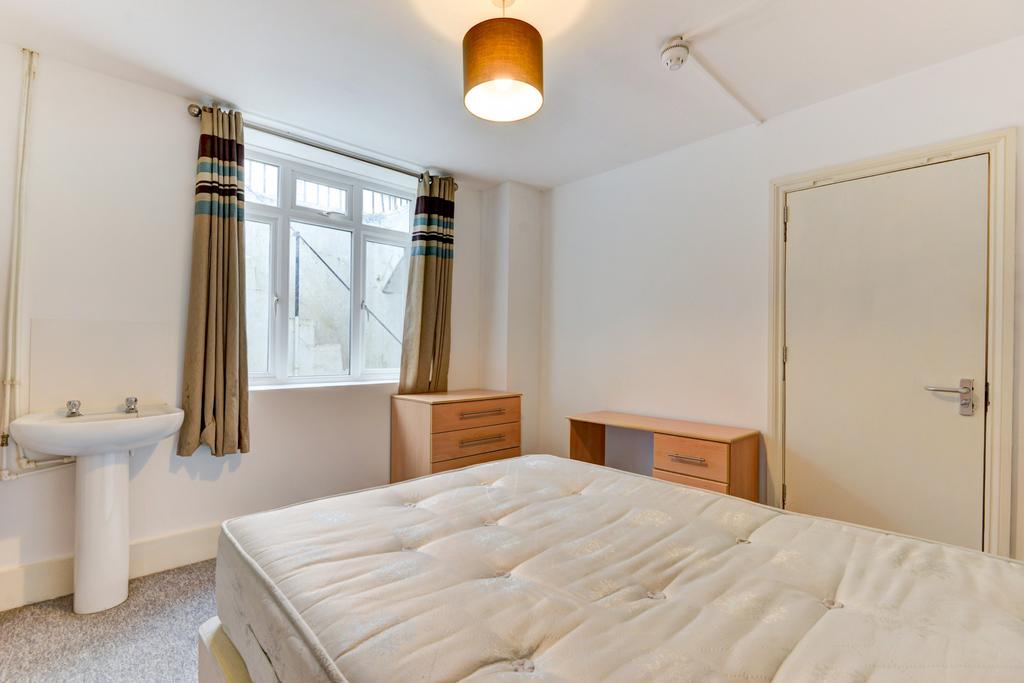 Bright, simply furnished bedroom with a large w...