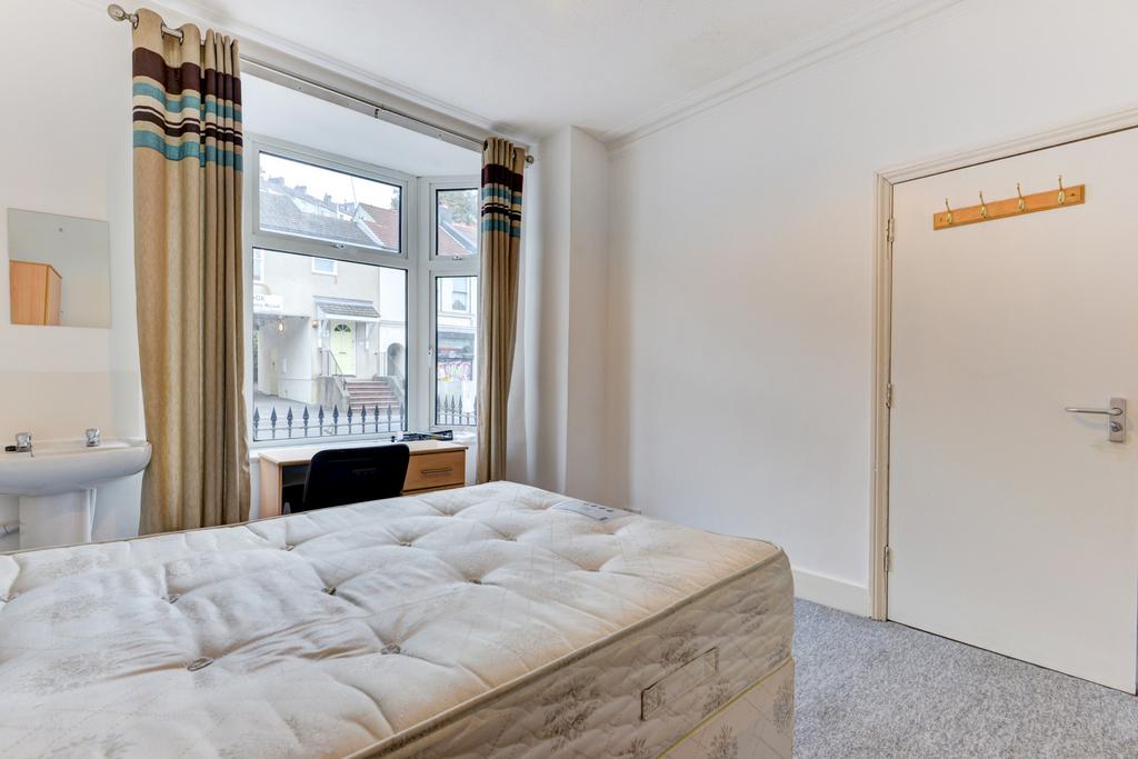 A bright and well-maintained bedroom featuring ...