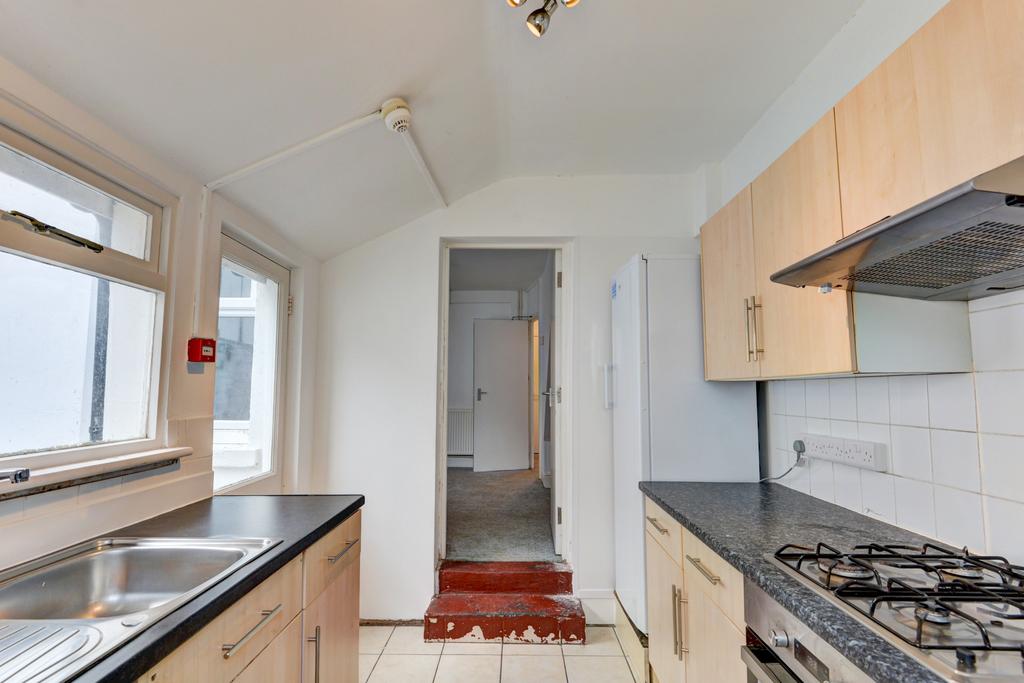 Bright galley kitchen with large sink by the wi...