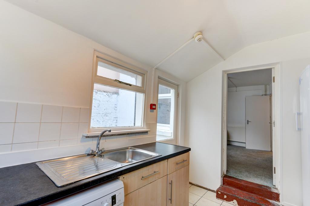 Bright kitchen with a large sink, tiled splashb...