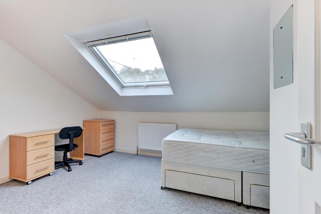 Bright attic bedroom with a large skylight, fit...