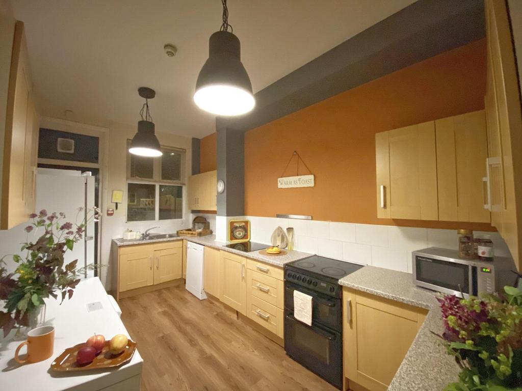 Warm, modern kitchen with wooden cabinets, inte...