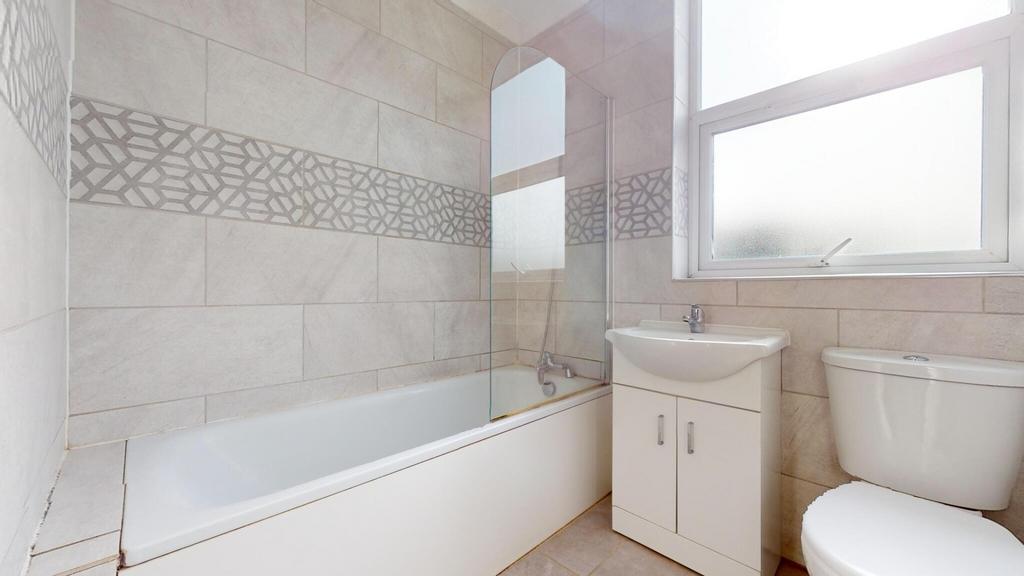 Bright, modern bathroom with a bath and shower ...