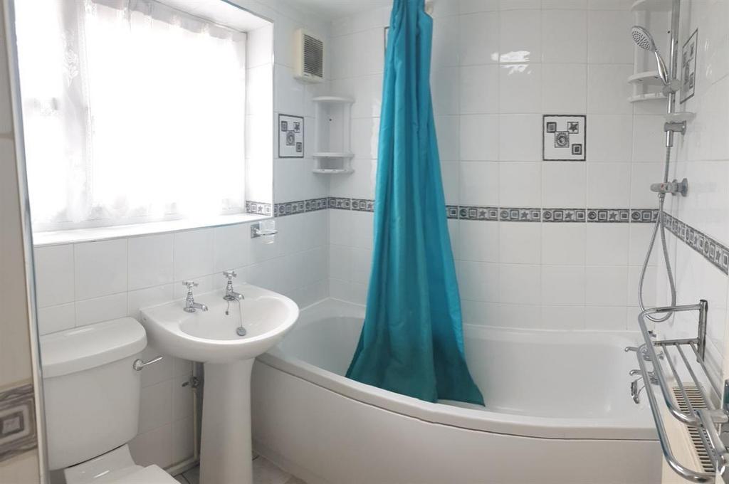 Bright, well-appointed bathroom with a curved b...