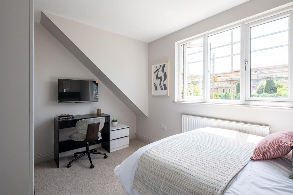 Bright, neatly presented bedroom featuring a co...