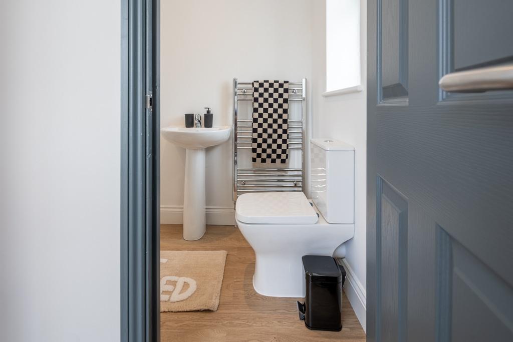 Bright, neatly presented bathroom with white sa...